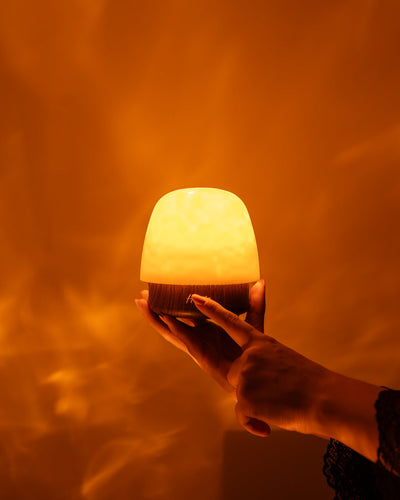 Une main tient une Havie allumée dans une lumière chaude