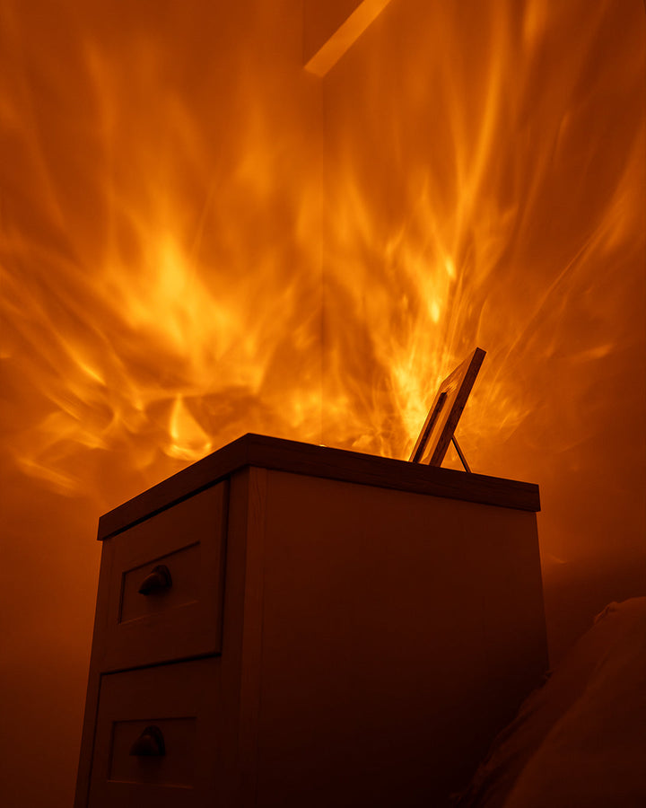 Les reflets chauds de Havie, comme des flammes, se répandent sur le mur au-dessus d'une commode