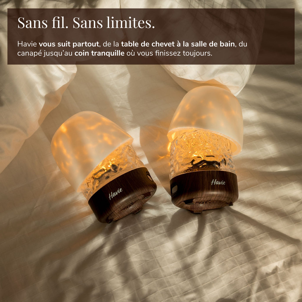 Deux lampes Havie rechargeables et sans fil brillent chaleureusement sur un lit.