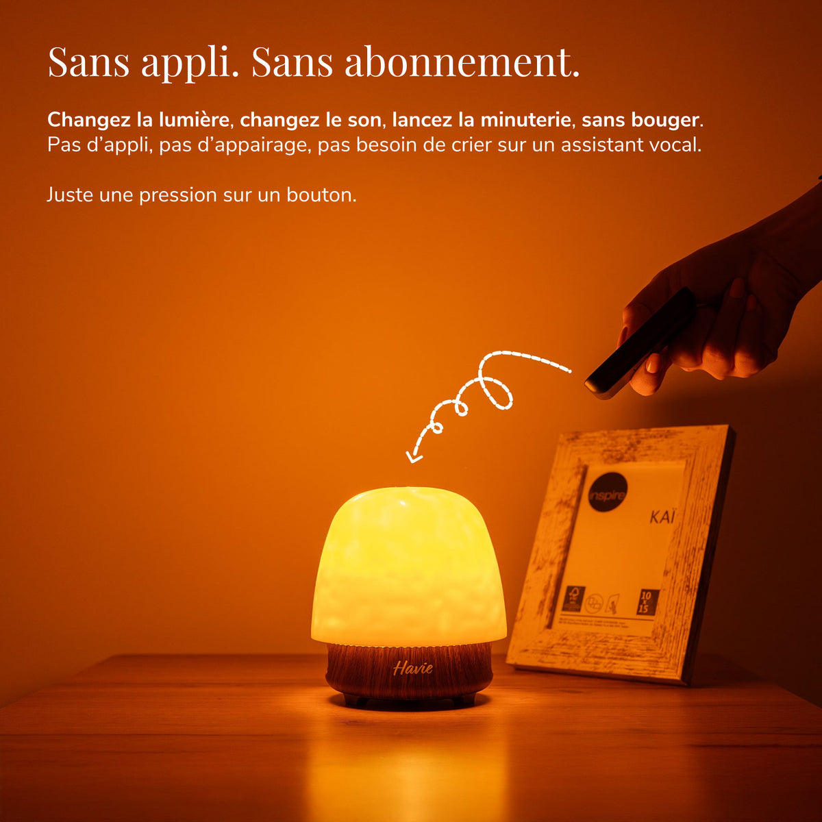 Havie se commande à la télécommande et diffuse une lueur orange chaleureuse sur une table de chevet.